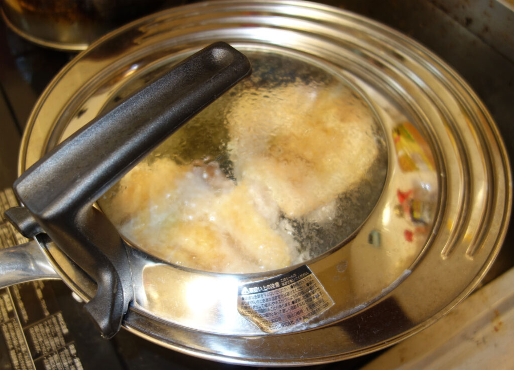 ガラス蓋つき鍋で何かを調理している様子