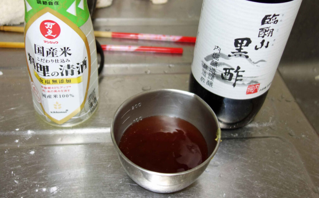 料理酒と黒酢と調味料が入った計量カップ