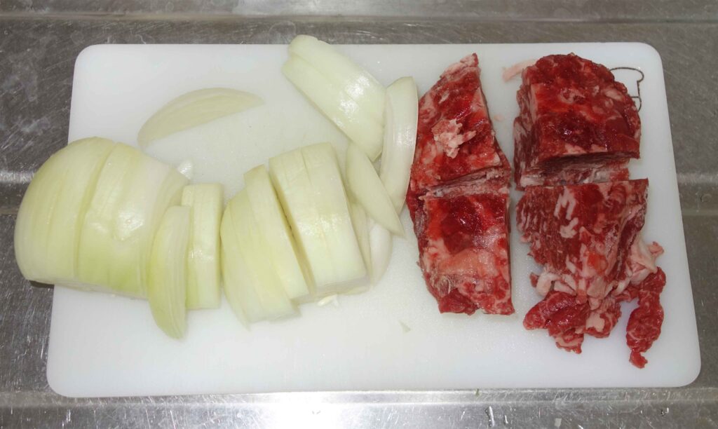 まな板の上のカットされた玉ねぎと牛肉