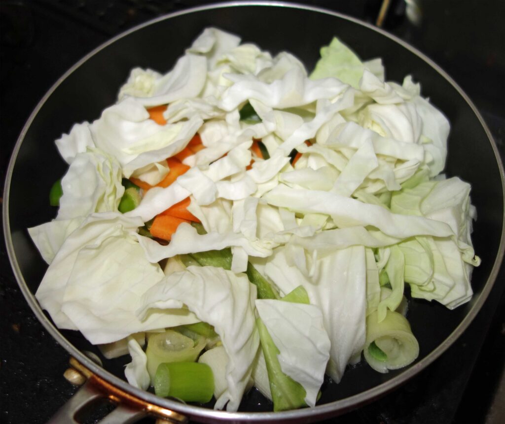 フライパンで炒めるキャベツと人参