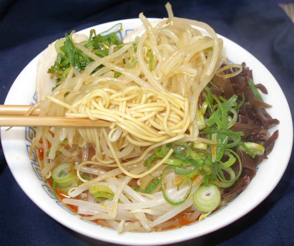 箸で麺を持ち上げているラーメン