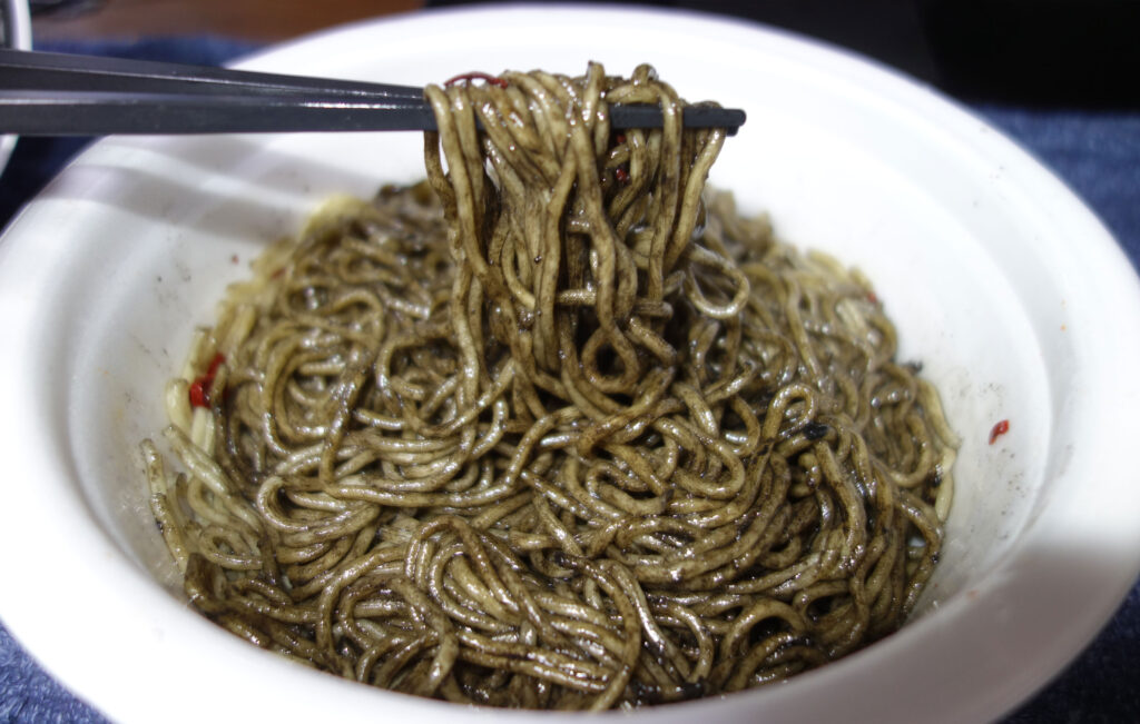 箸で持ち上げられたイカスミ焼きそば