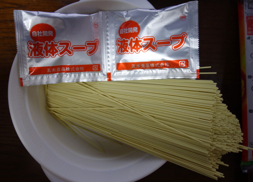 皿に盛られた麺と液体スープの袋