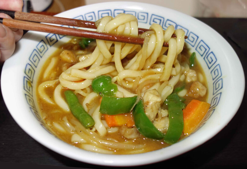 箸で持ち上げられたカレーうどん
