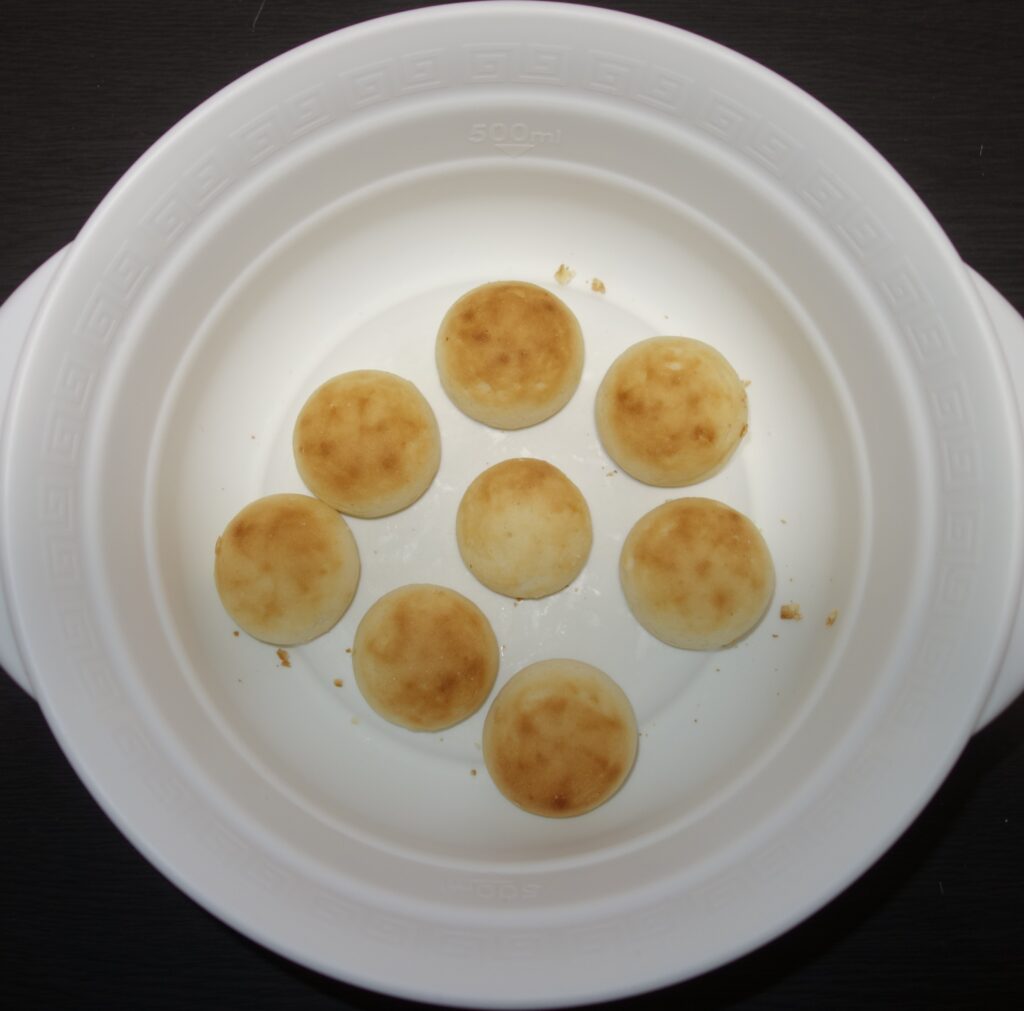 白い皿に入った丸くて焼き色のついたクリームパン