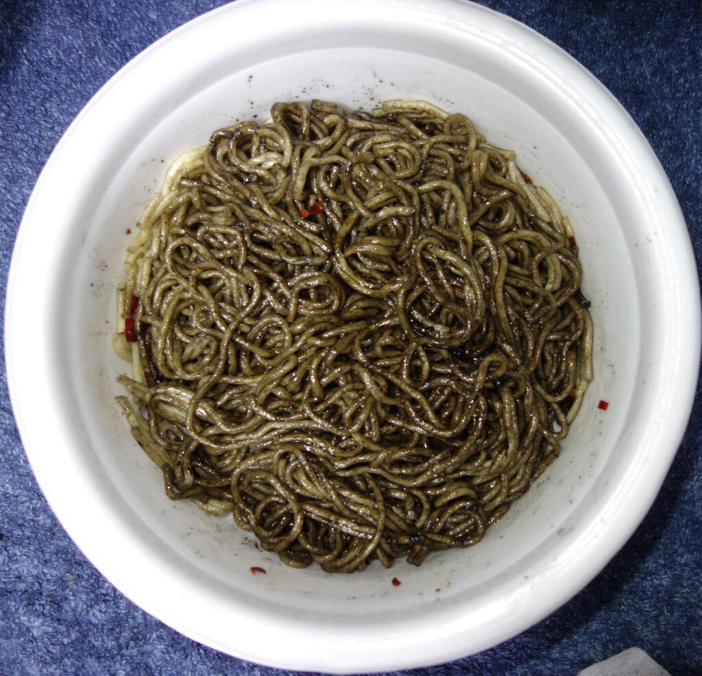 白い器に入った黒い麺料理