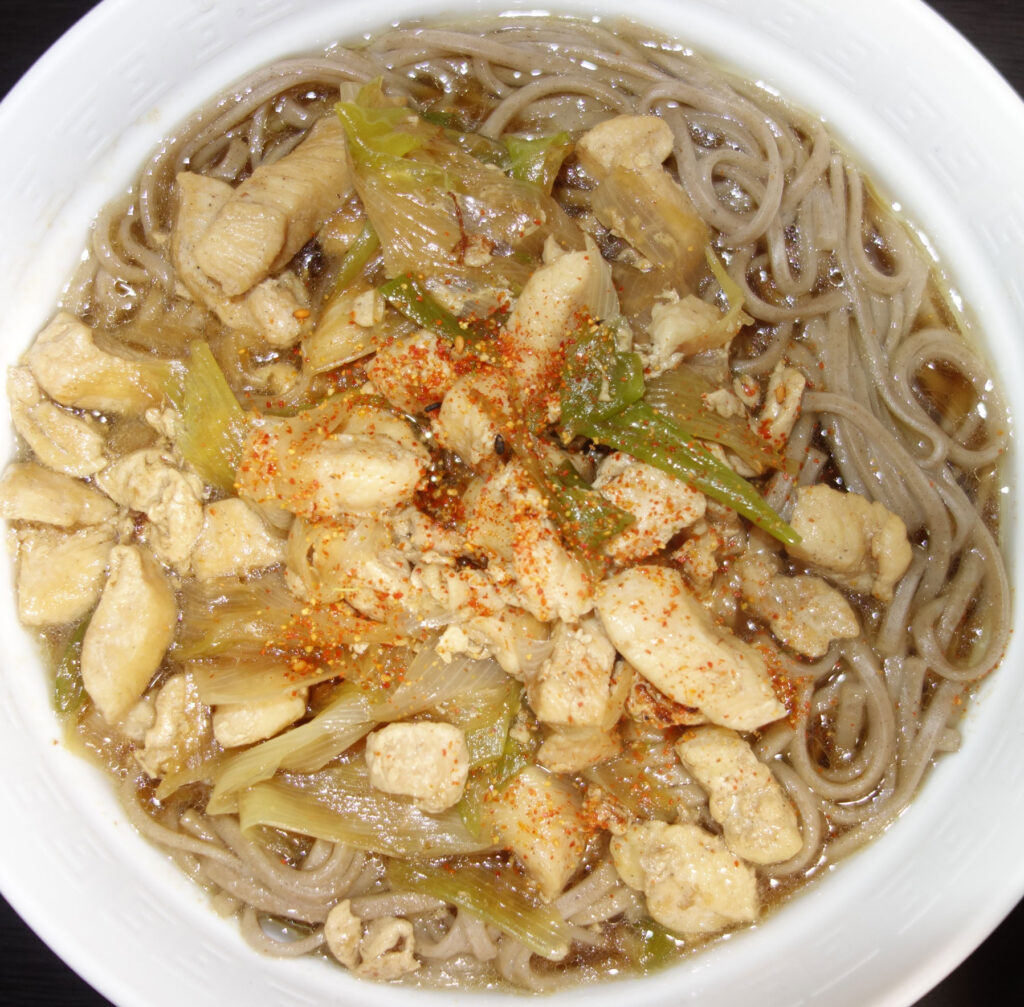 鶏肉とネギがのった温かいそば
