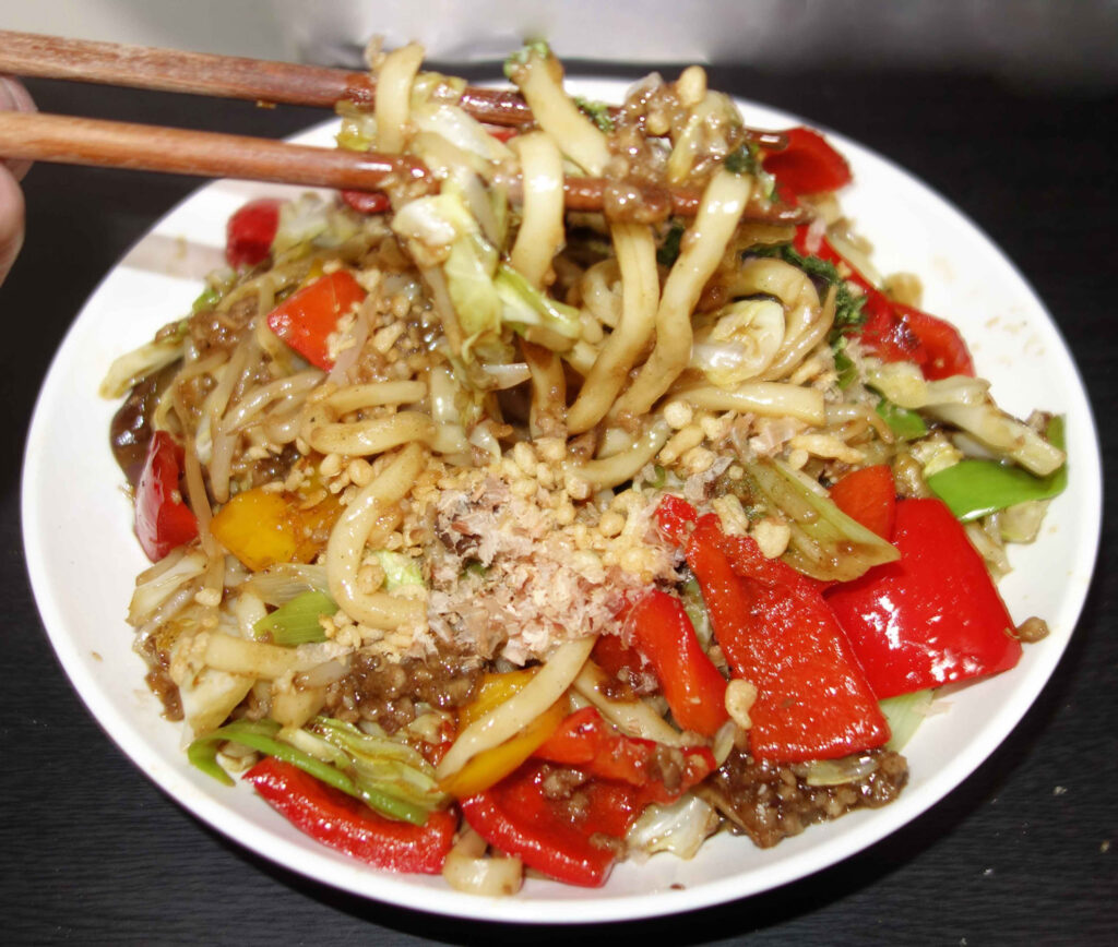 箸で持ち上げられた野菜炒めうどん