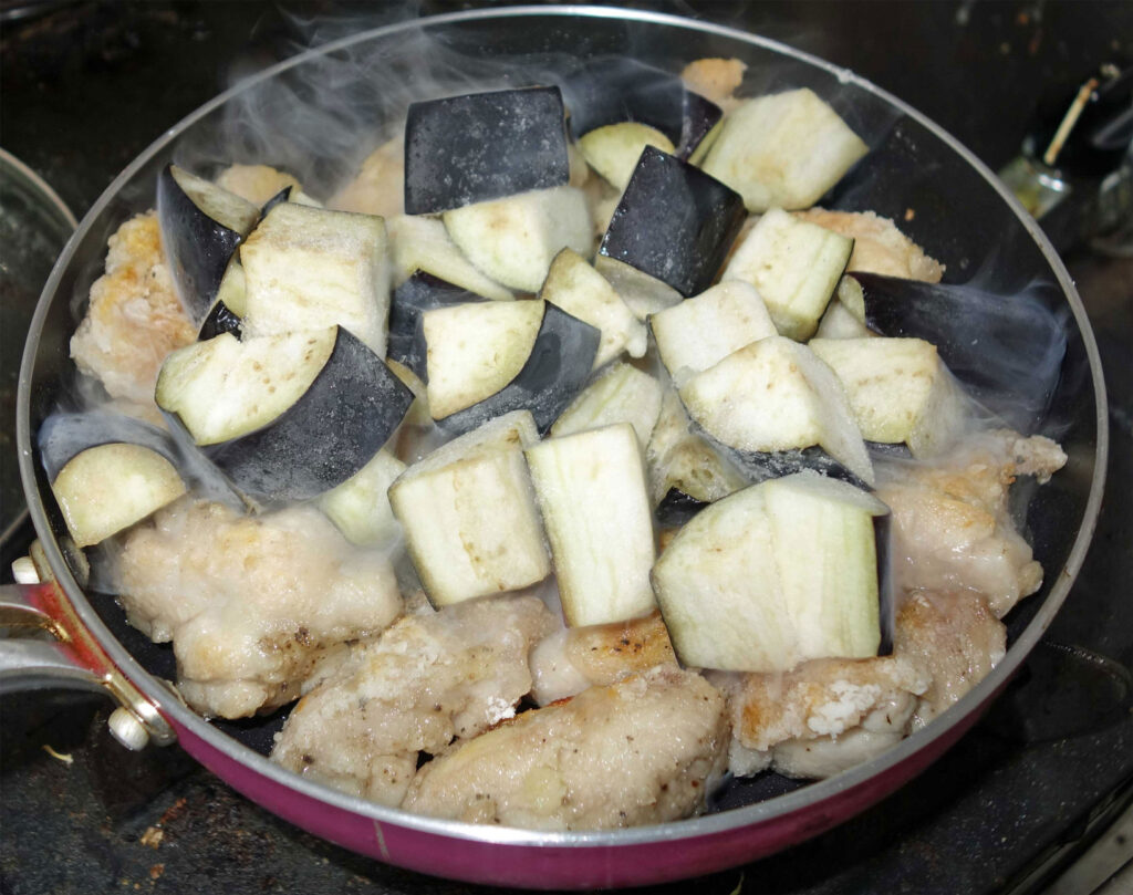 鶏肉とナスを炒めているフライパン
