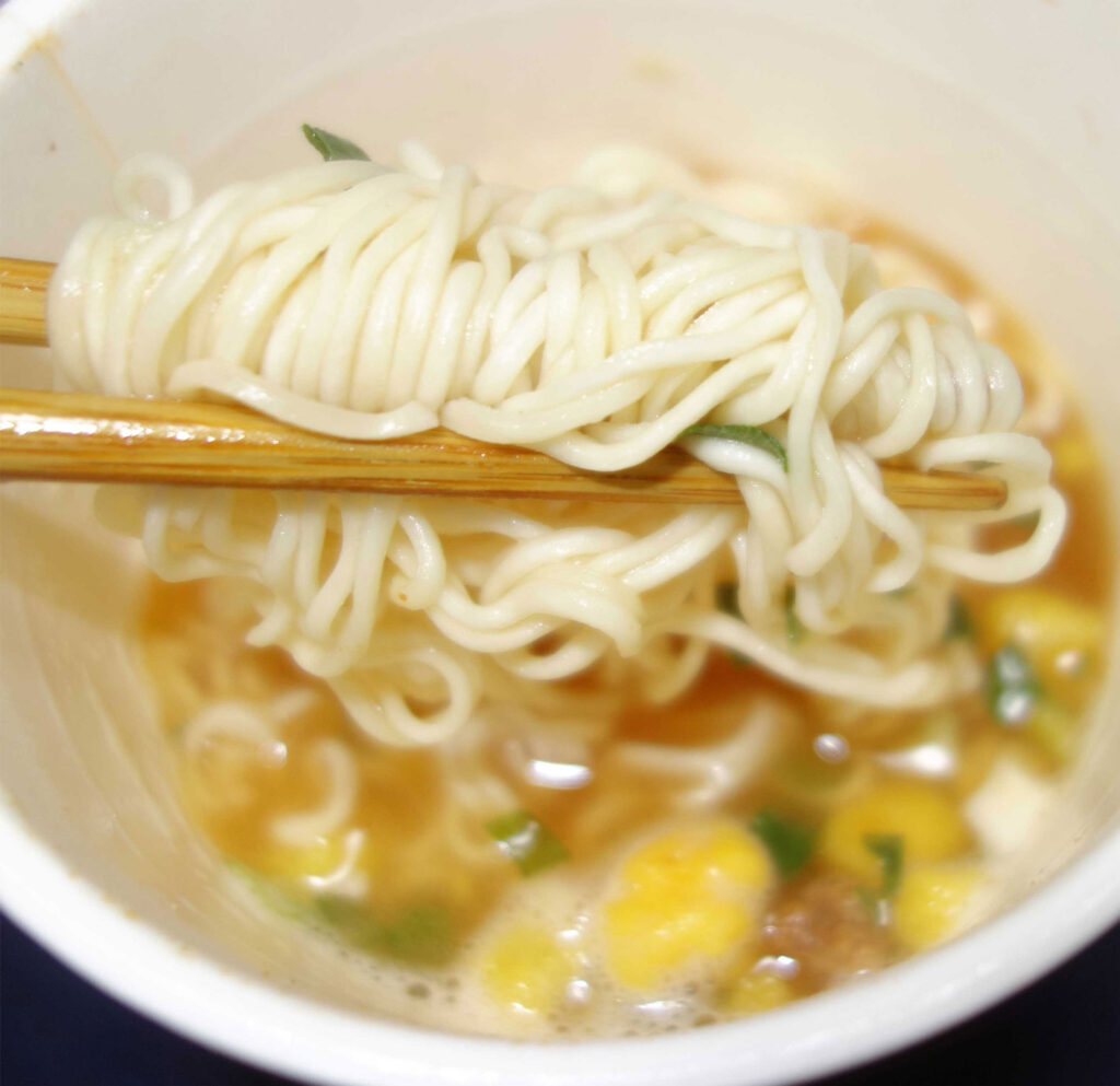 箸で持ち上げられたカップ麺の麺