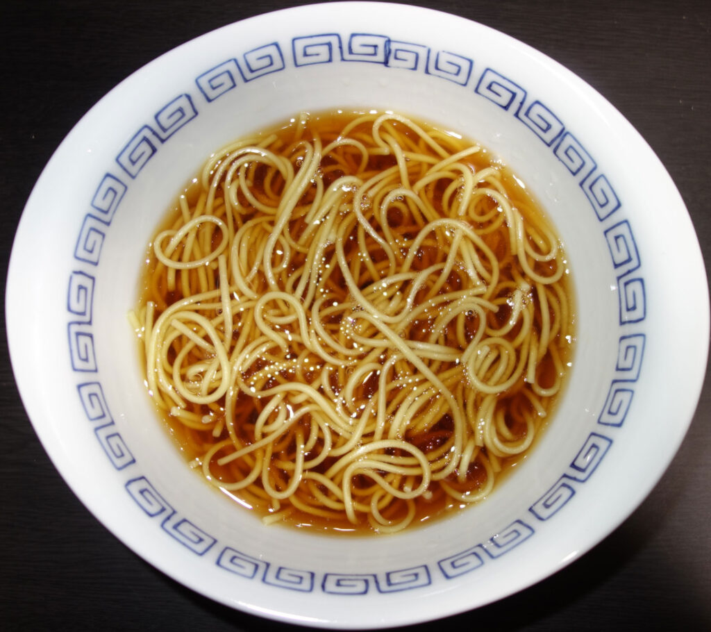 白い丼に入った透明なスープのラーメン