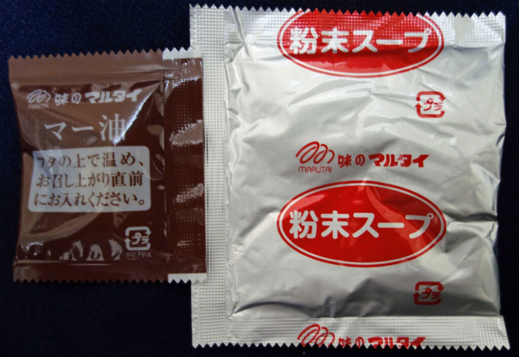 マルタイラーメンの粉末スープとマー油の小袋