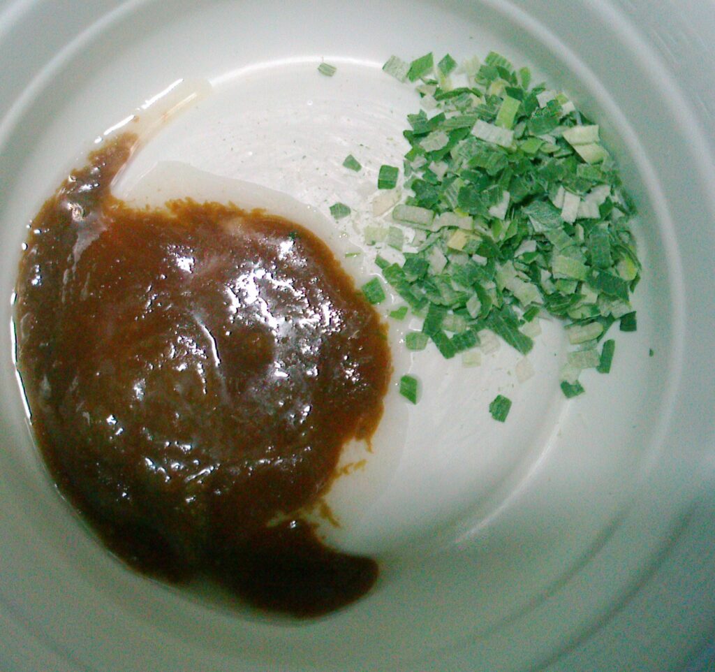 白いお皿にタレとネギ