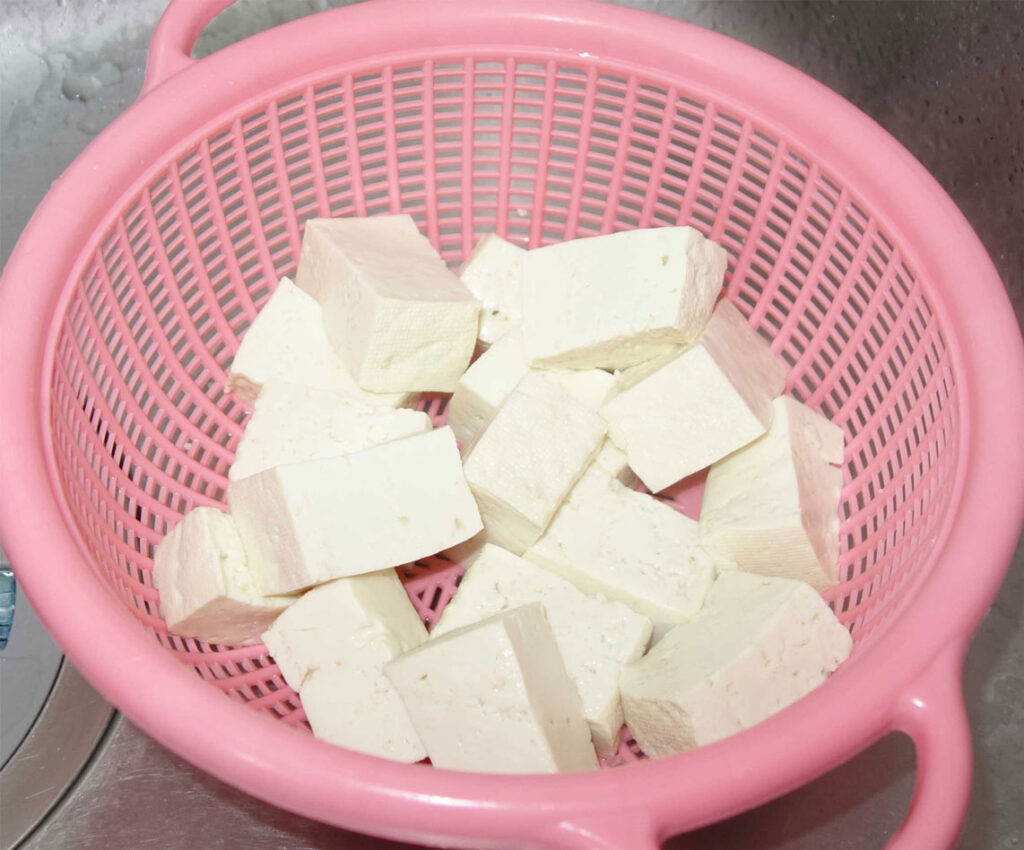 ピンク色のザルに入った豆腐