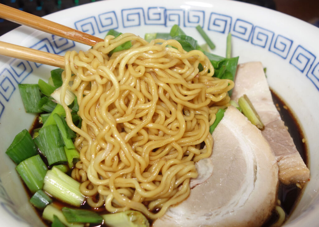 箸で持ち上げられた富山ブラック