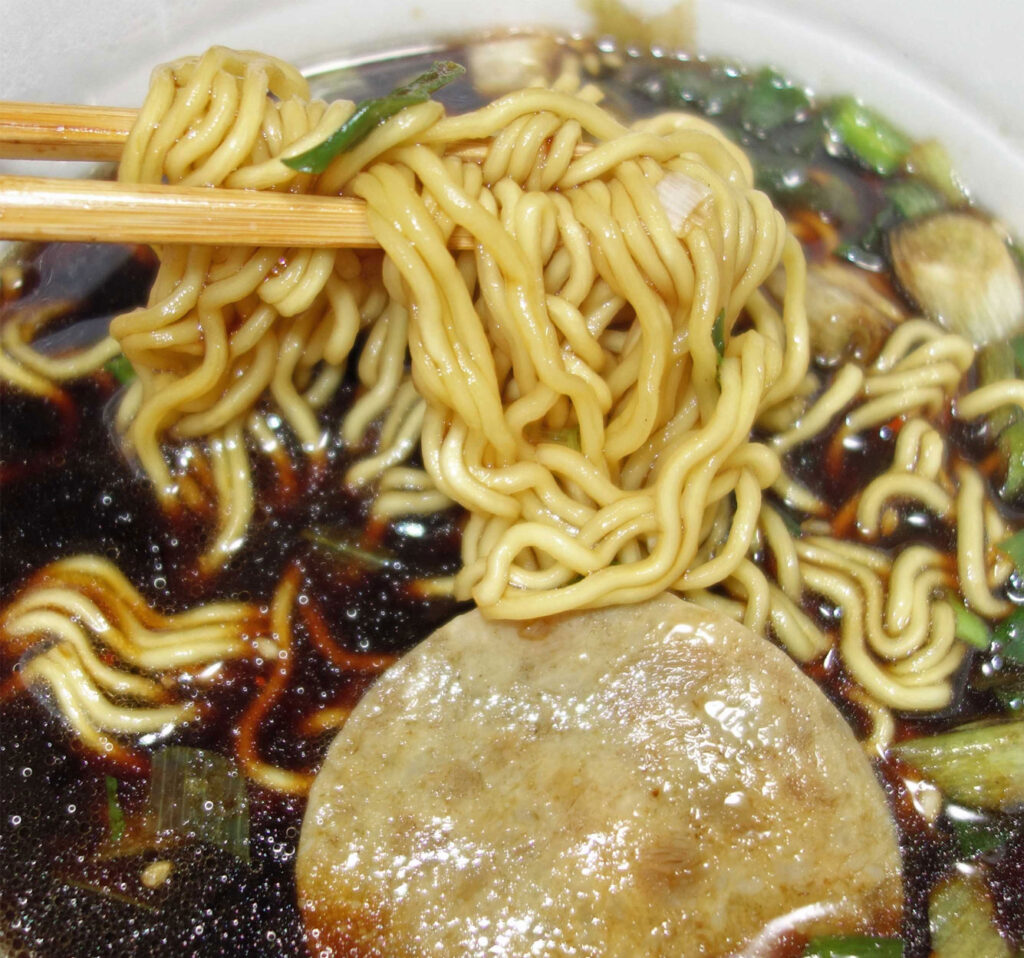 箸で持ち上げられたラーメン