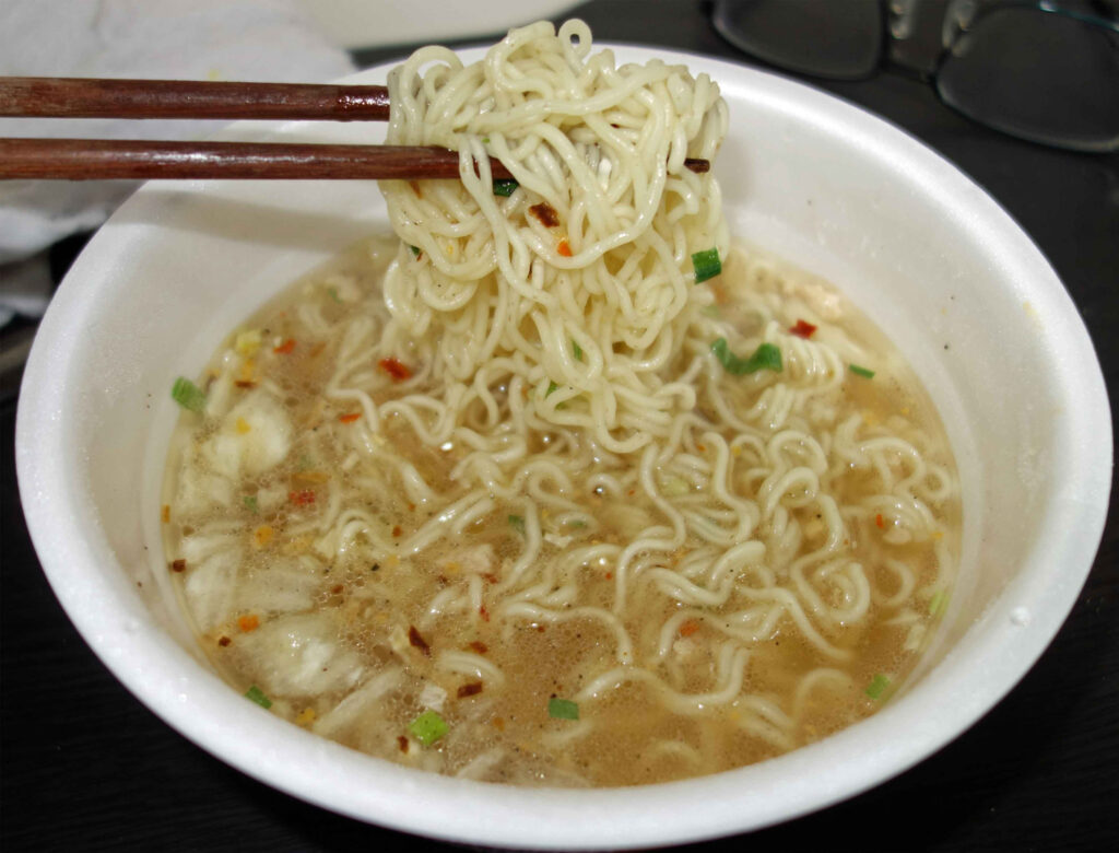 割り箸で持ち上げられたカップラーメン