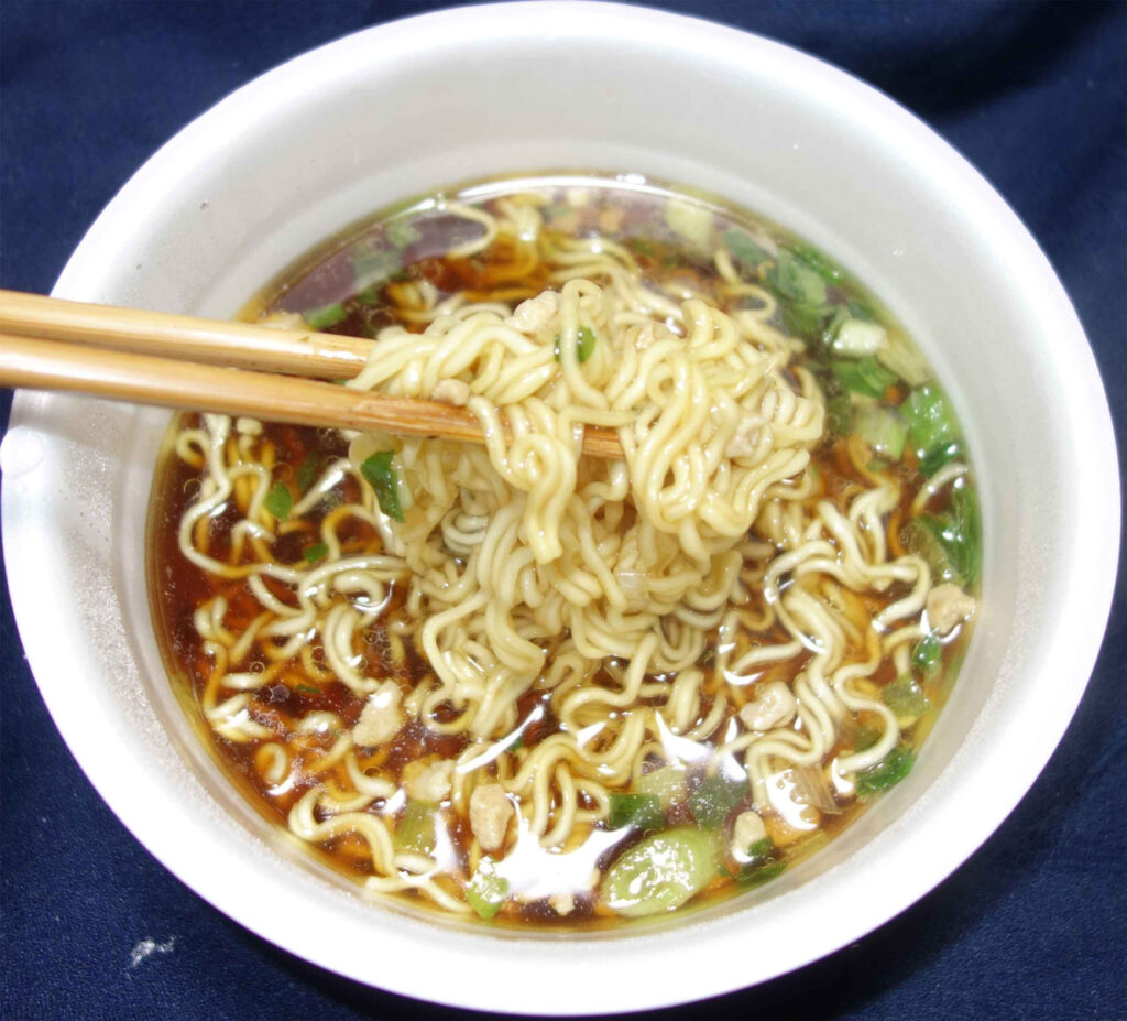 箸で持ち上げられたカップ麺