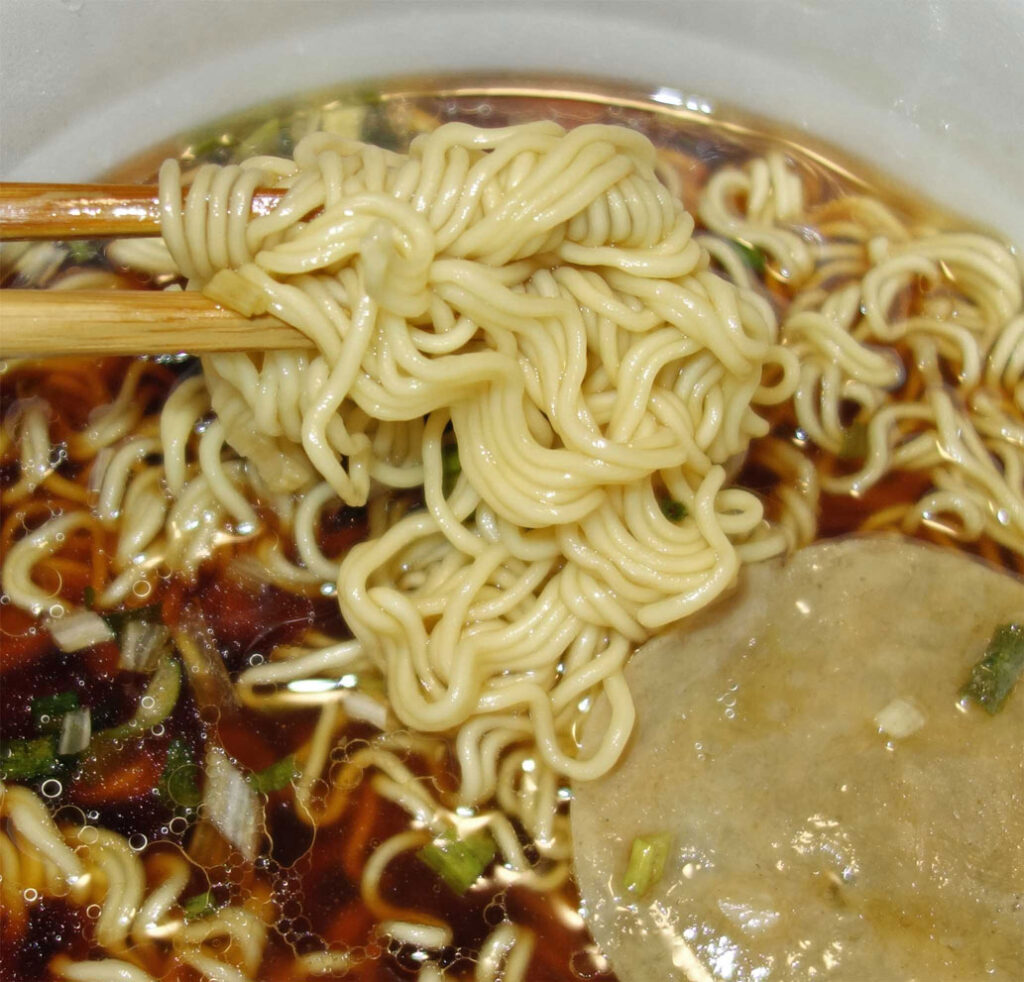 箸で持ち上げられたラーメン