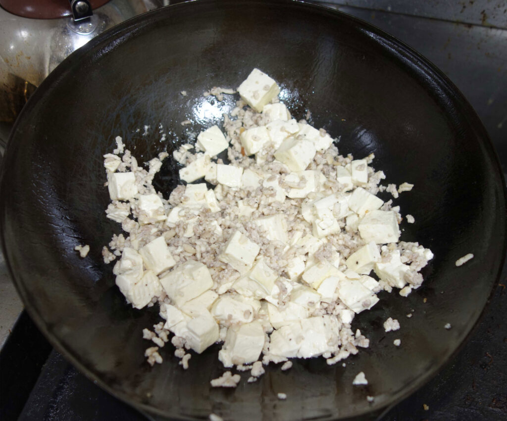フライパンで調理中の豆腐とひき肉